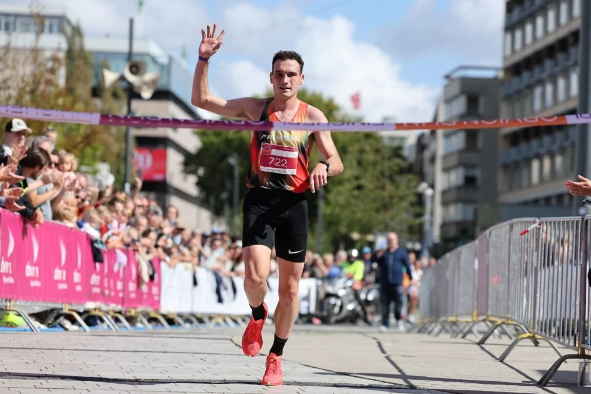 Male runner crossing the finish line as winner of the race.