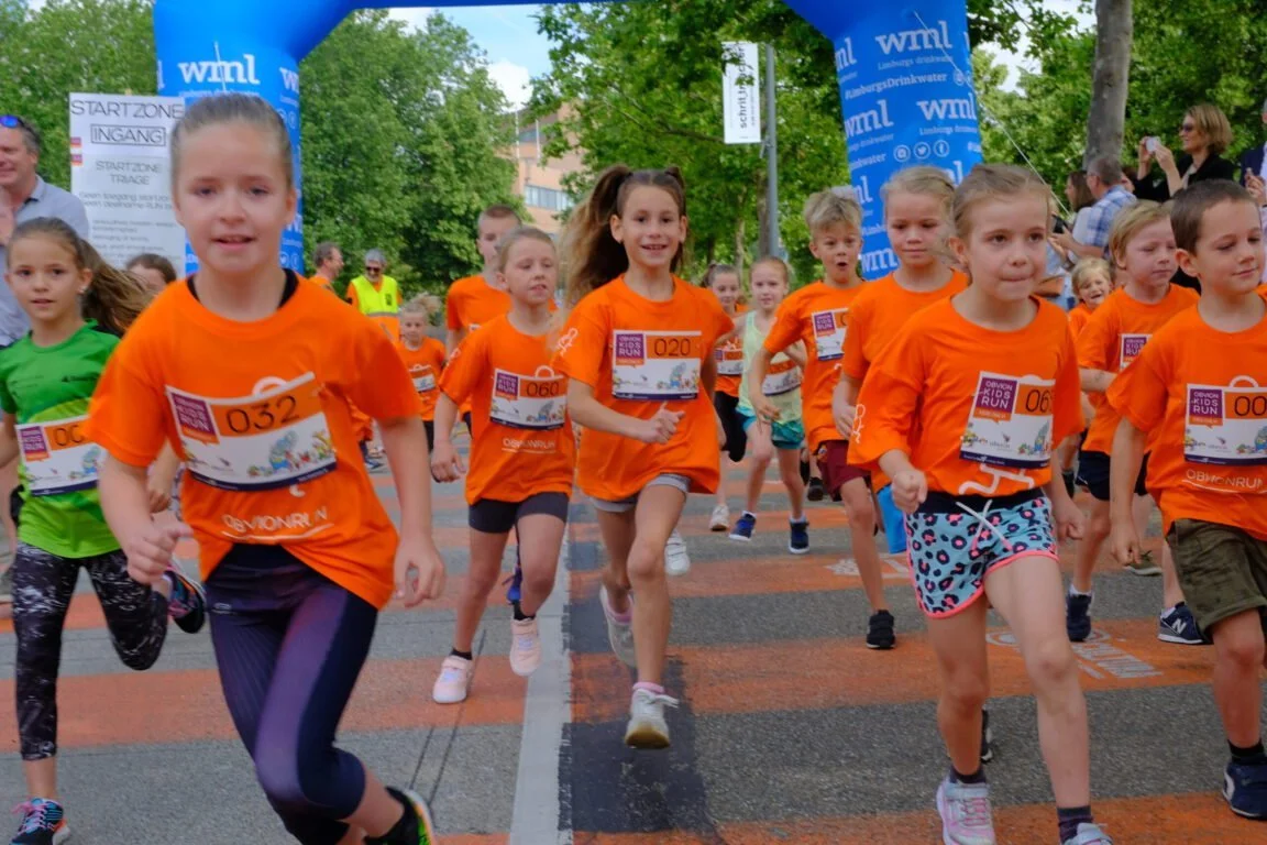 Children running and smiling during a kids race, enjoying sport and outdoor activity.