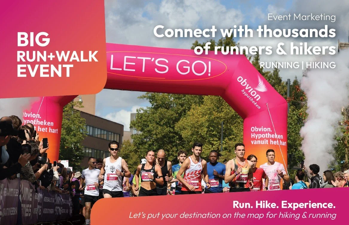 A group of runners participating in a large run and walk event under a pink inflatable arch with the words 'LET'S GO!' during daytime. Spectators line the sides of the street, and trees and buildings are visible in the background.