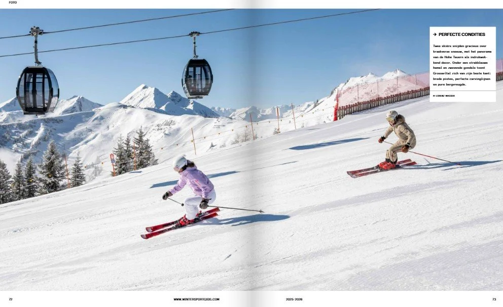 Two skiers decending a snowy ski slope in the mountains with a cable car