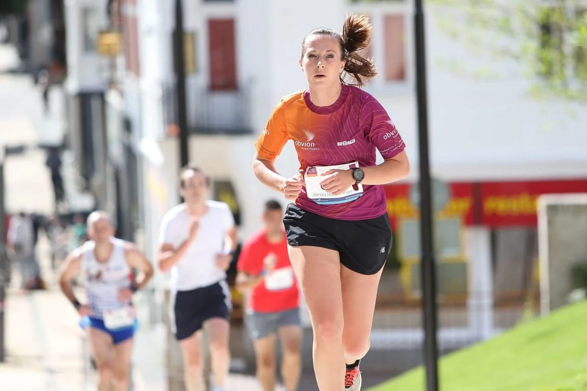 Focused female runner during the event, showing effort and determination.