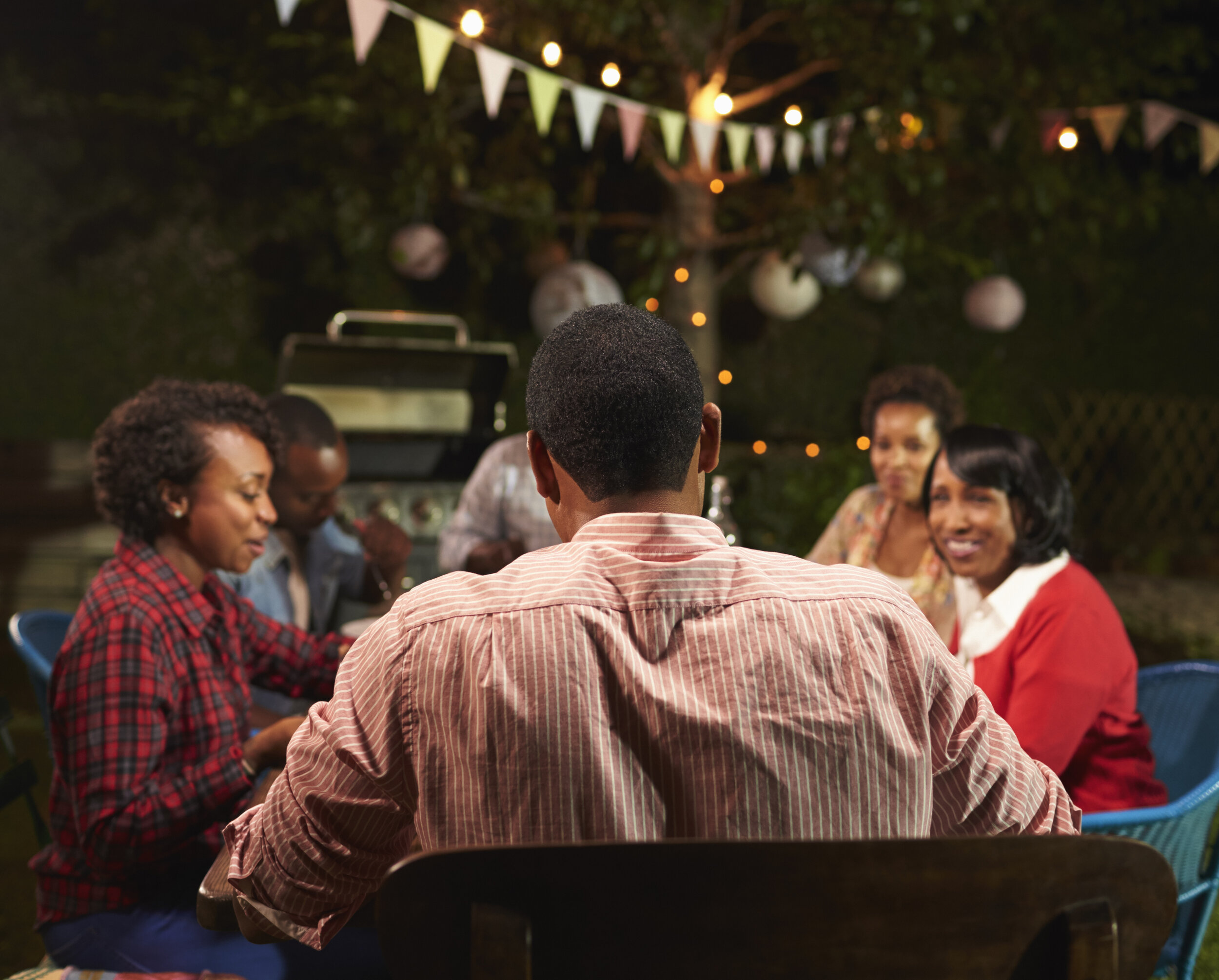 adult-black-family-enjoying-dinner-in-their-garden-PB6HGWE.jpg