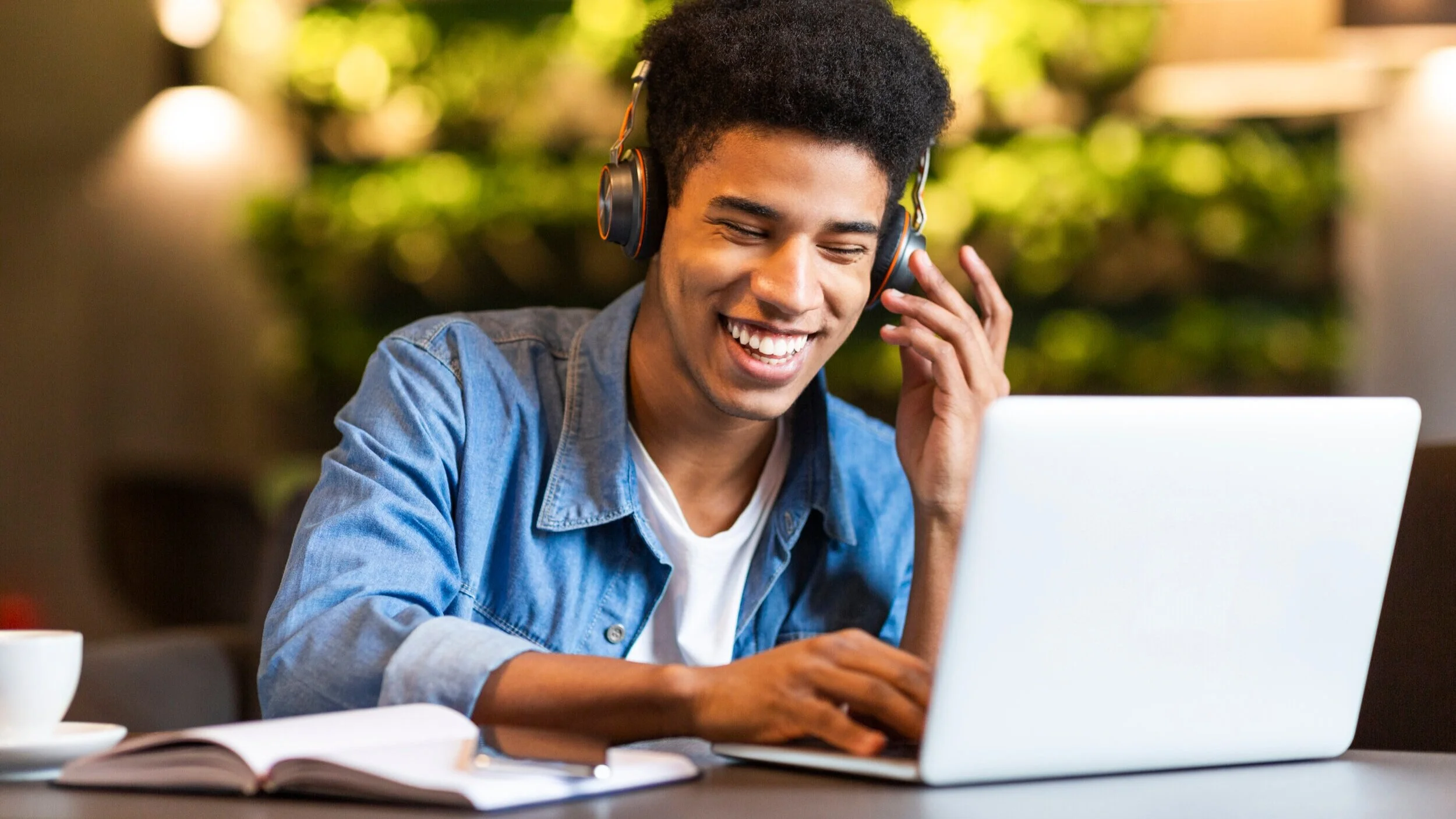 cheerful-teen-guy-with-headset-looking-at-laptop-9UH8LRA.jpg