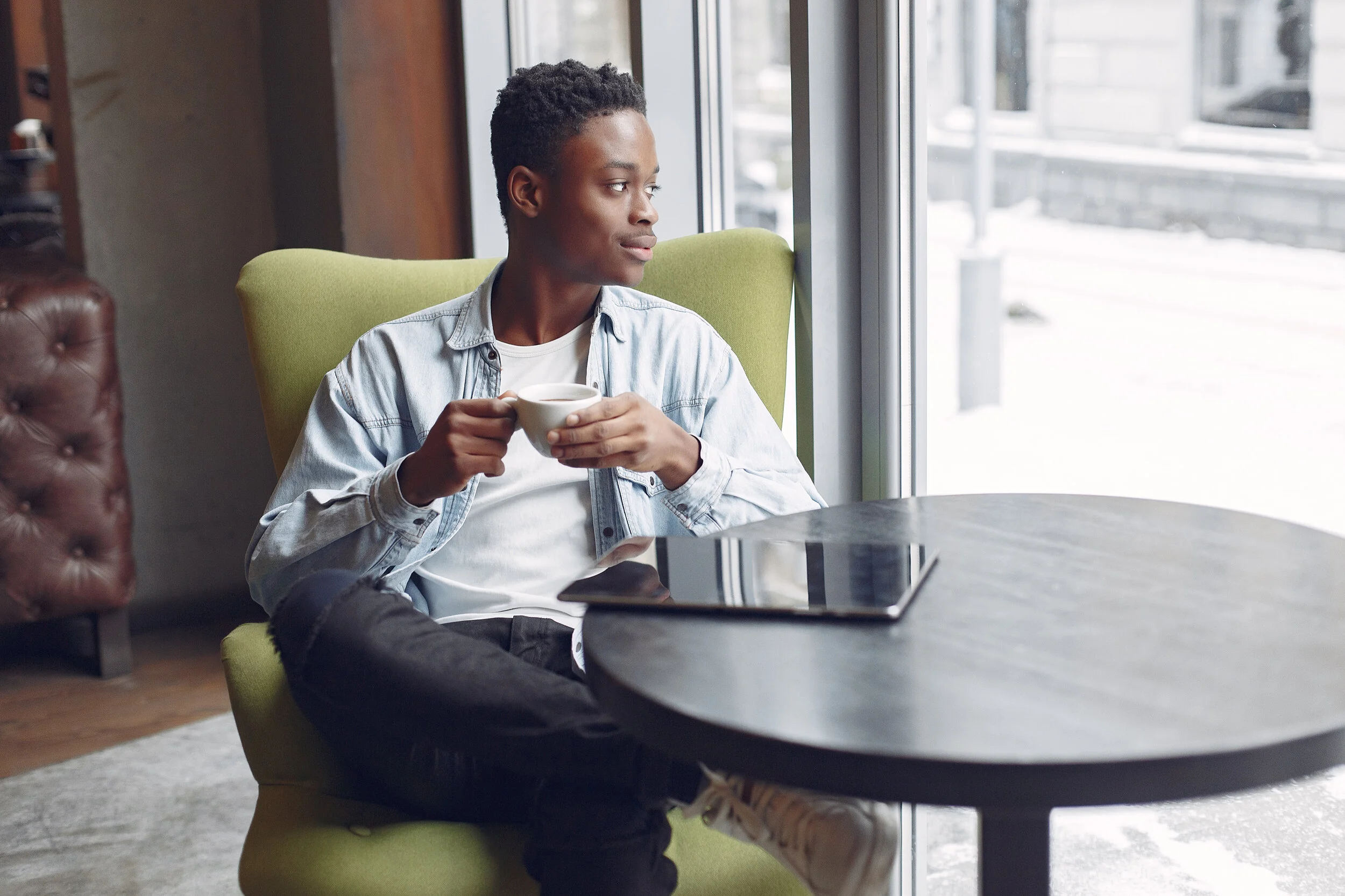 black-man-sitting-in-a-cafe-and-drinking-a-coffee-MDCALXE.jpg