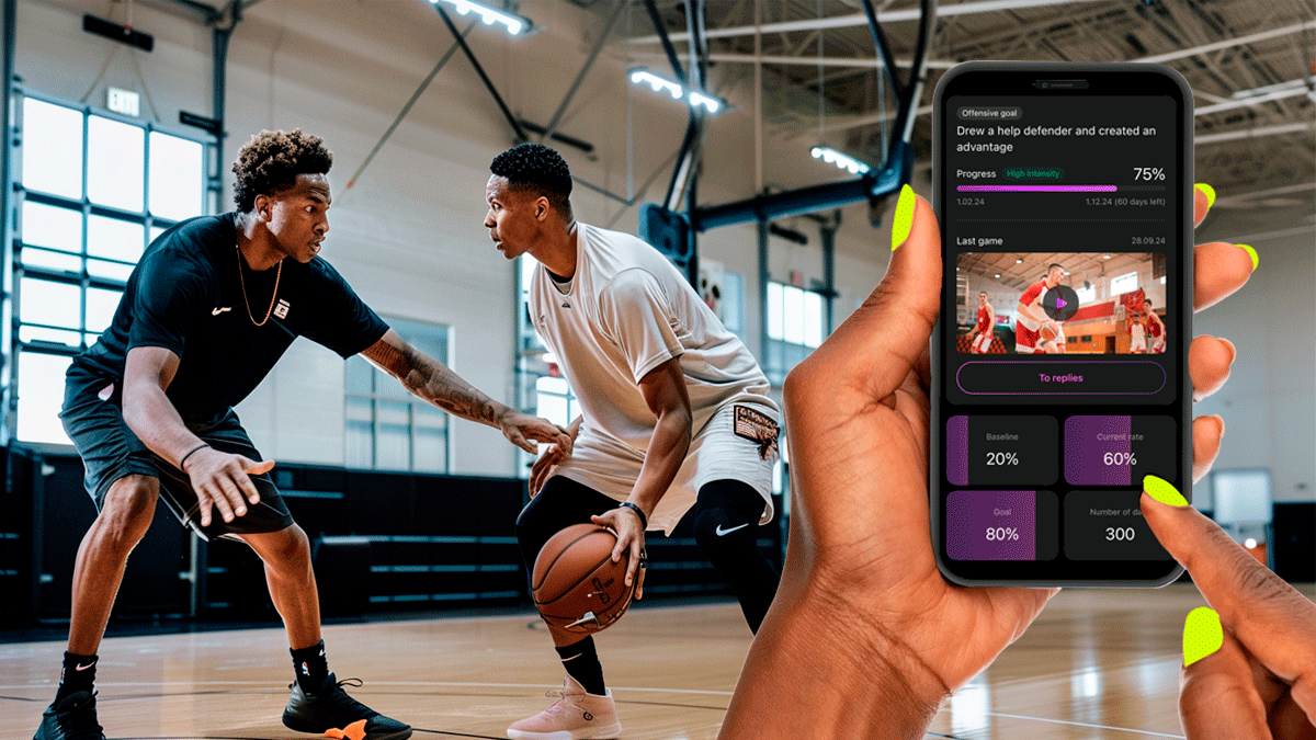Two basketball players competing in a Constraints Led Approach on an indoor court, while a hand holds a smartphone displaying a basketball player development app with progress data and a video of the practice session.