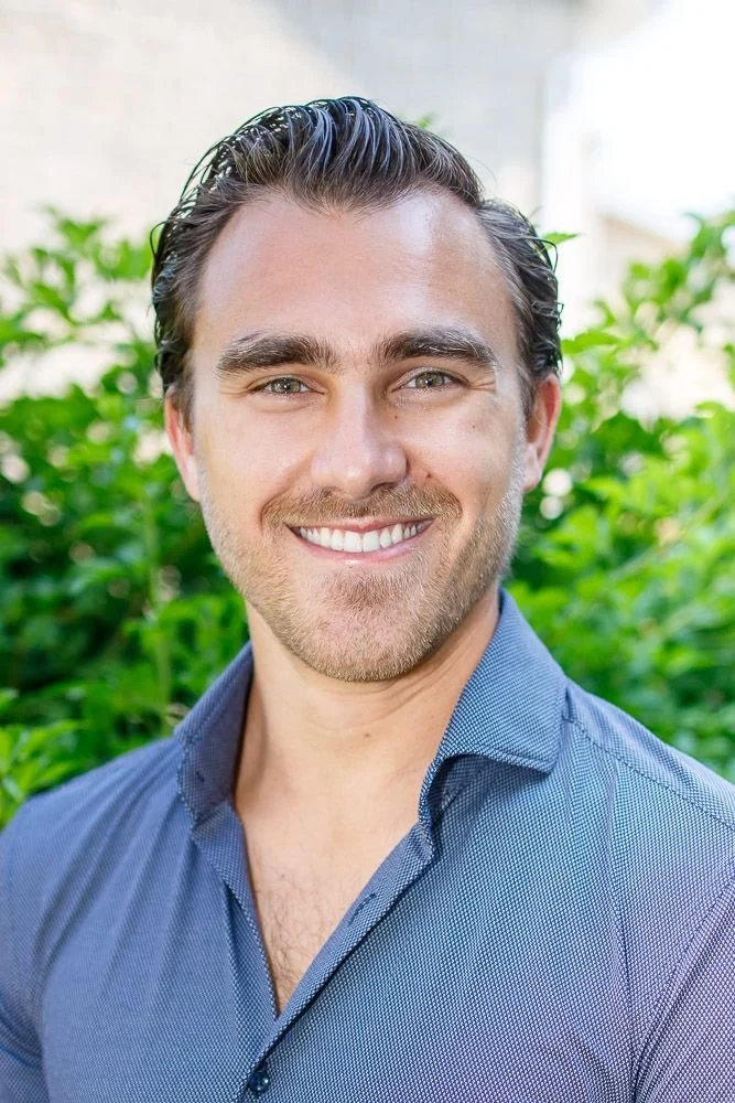 A headshot of Psychotherapist Chris Cebulski wearing a blue dress shirt, smiling.