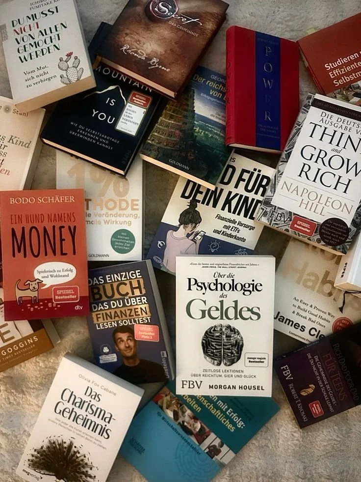 A collection of various books in German and English laid out on a surface.