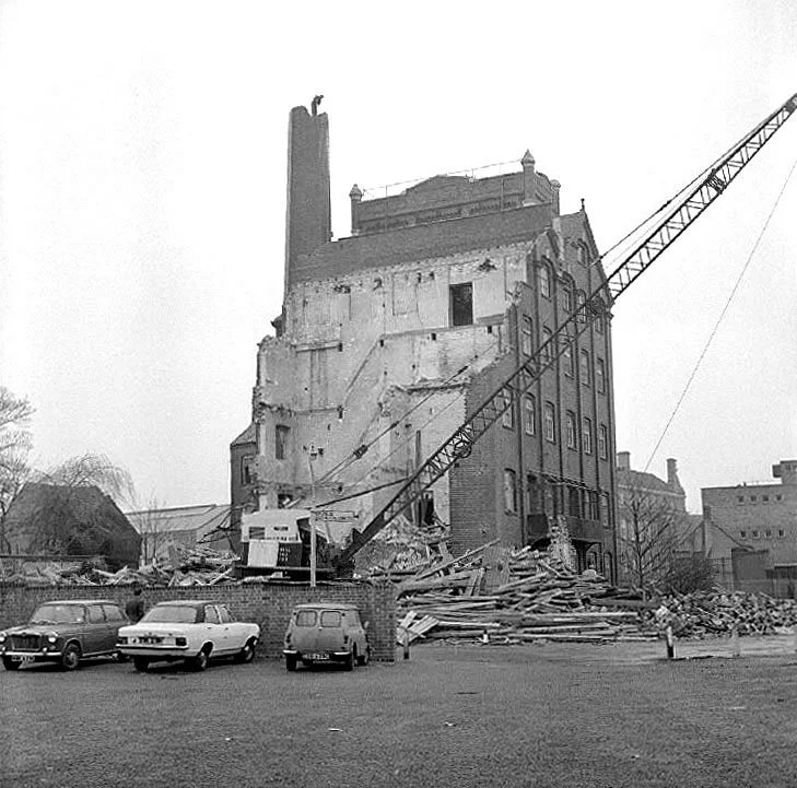 “Reproduced from the “Our Warwickshire” website ©. The photo shows the demolition of the flour mill in 1973. In the background you can see the side profile of the Town Hall and the George Eliot Building. 