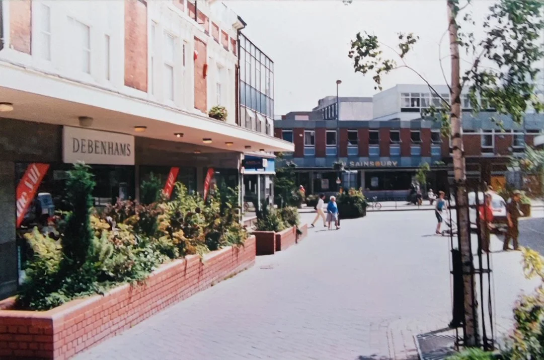 The same view in 1974. Debenhams now occupies the left side frontage, and next to Debenhams is the Anglia Building Society (you can recognise the windows from the 1932 photo).  J C Smiths Furniture has been demolished and Sainsbury's supermarket now 