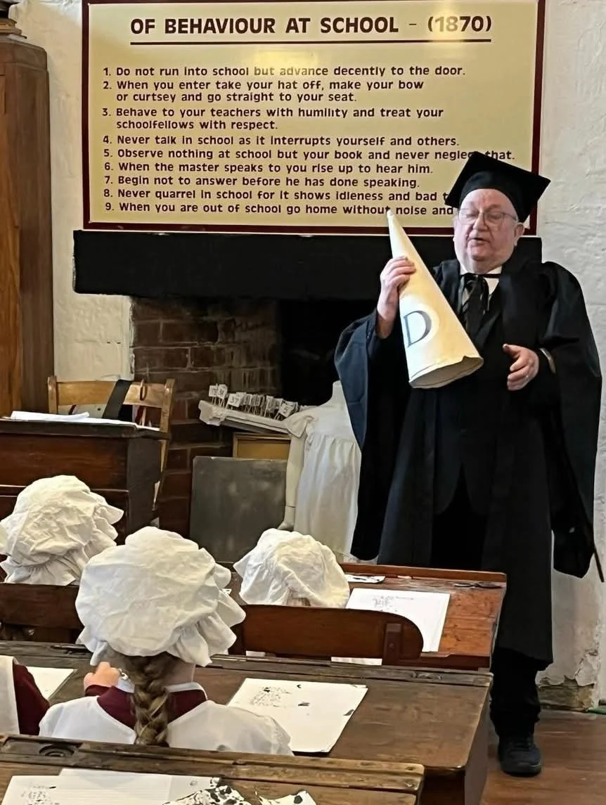 victorian teacher at front of class with pupils re-enactment