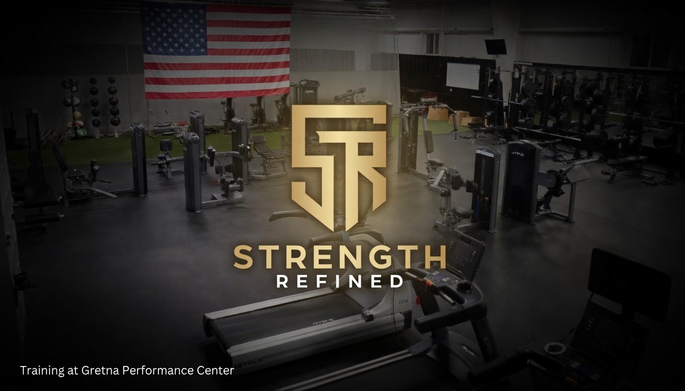 Empty gym with various workout equipment, American flag hanging on the wall, and a logo for 'Strength Refined' in the center.