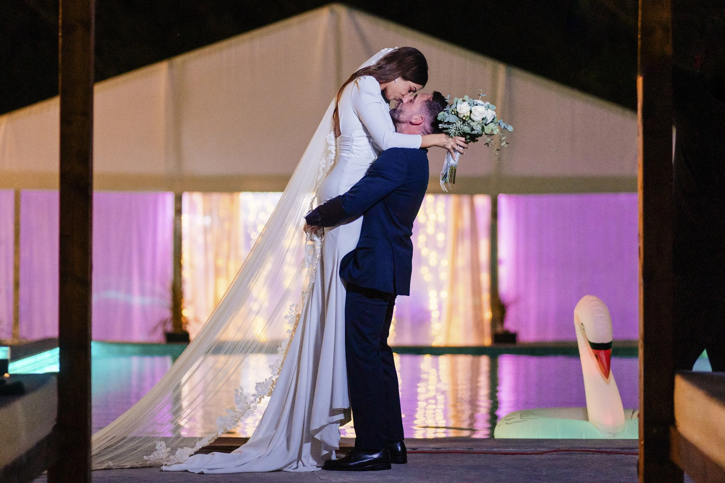 Casa moderna con piscina, tumbonas y jardín con plantas deserticas en un día nublado.