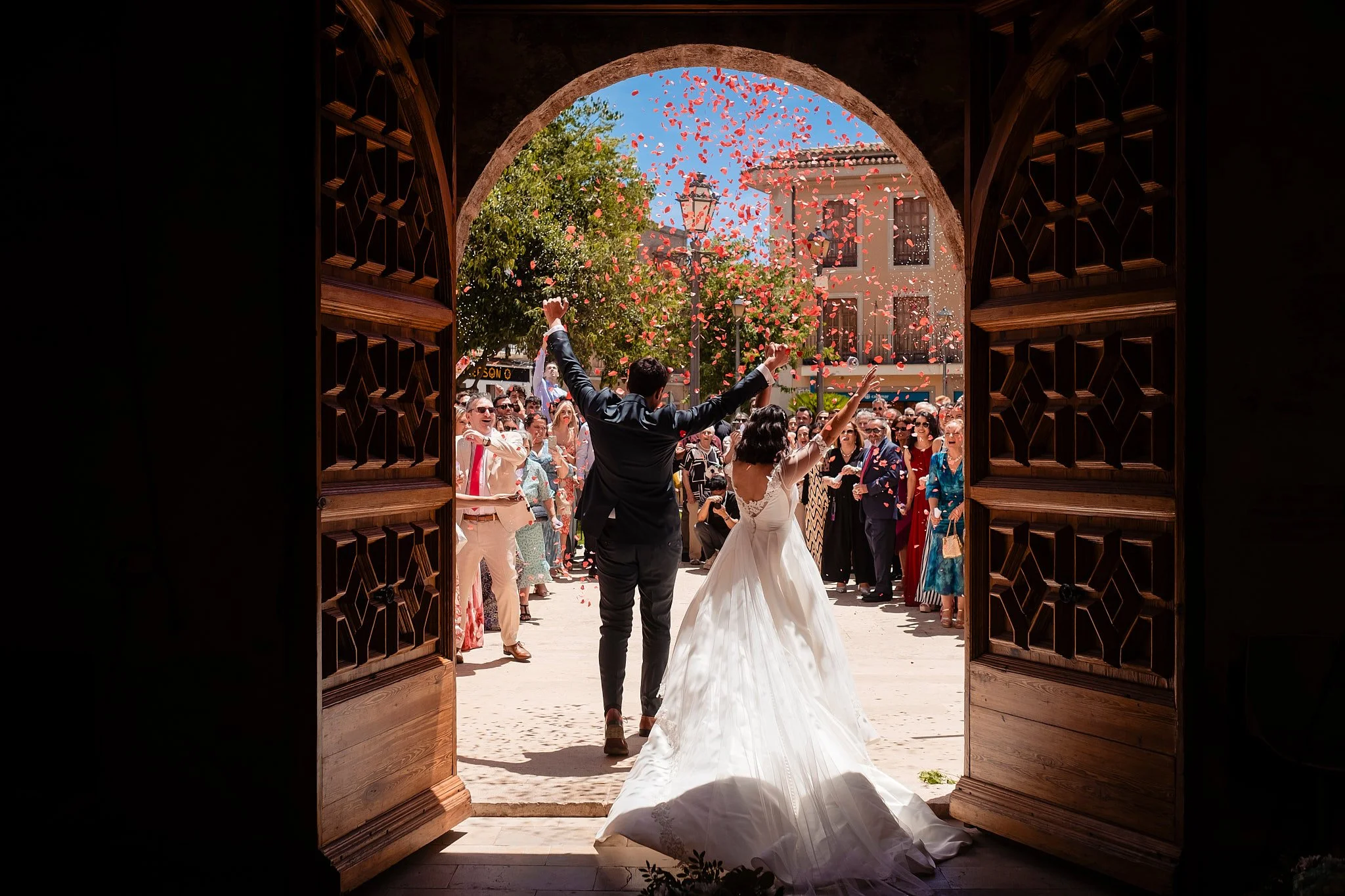 Mujer en vestido de novia bailando y rodeada de personas en celebración de boda.