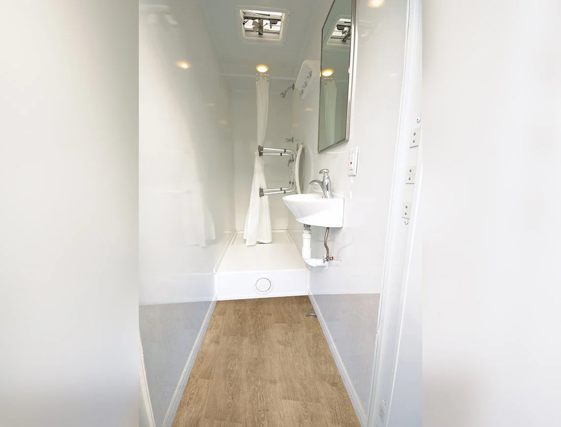 Private room with vanity sink and mirror in a mobile shower trailer