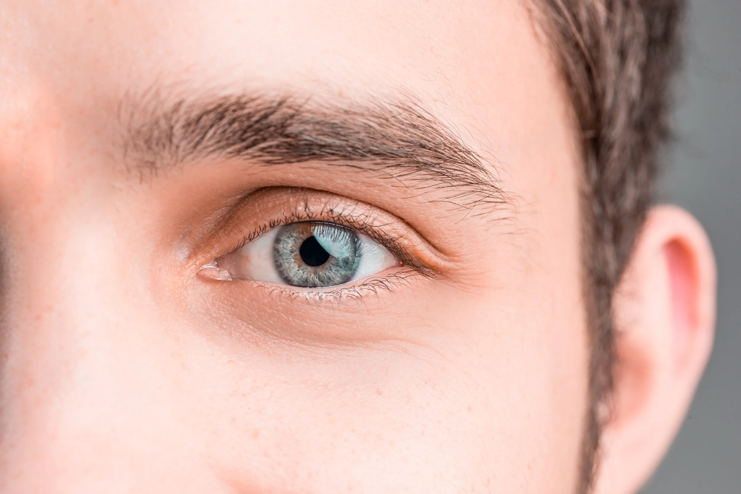 Extreme close-up of a man's blue-gray eye