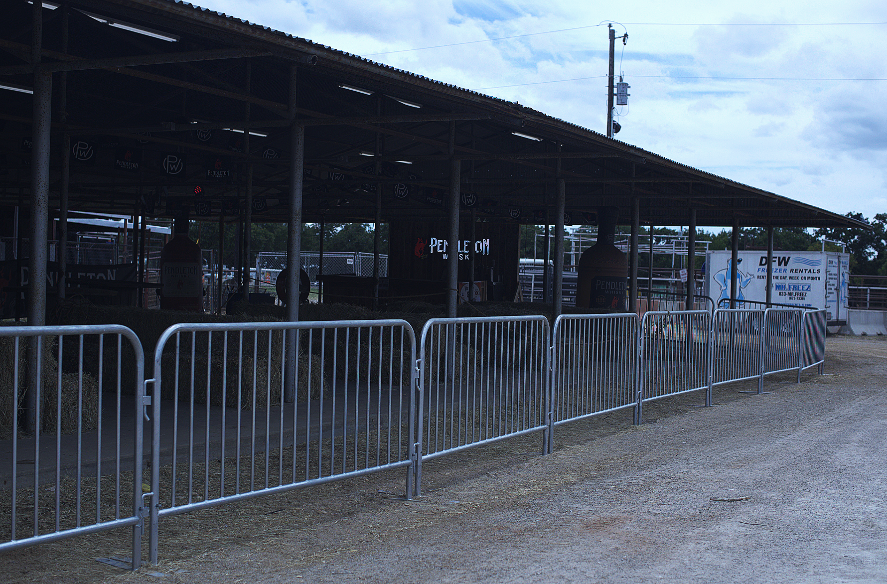 Steel bike barricades lined up along a drive outside a livestock arena