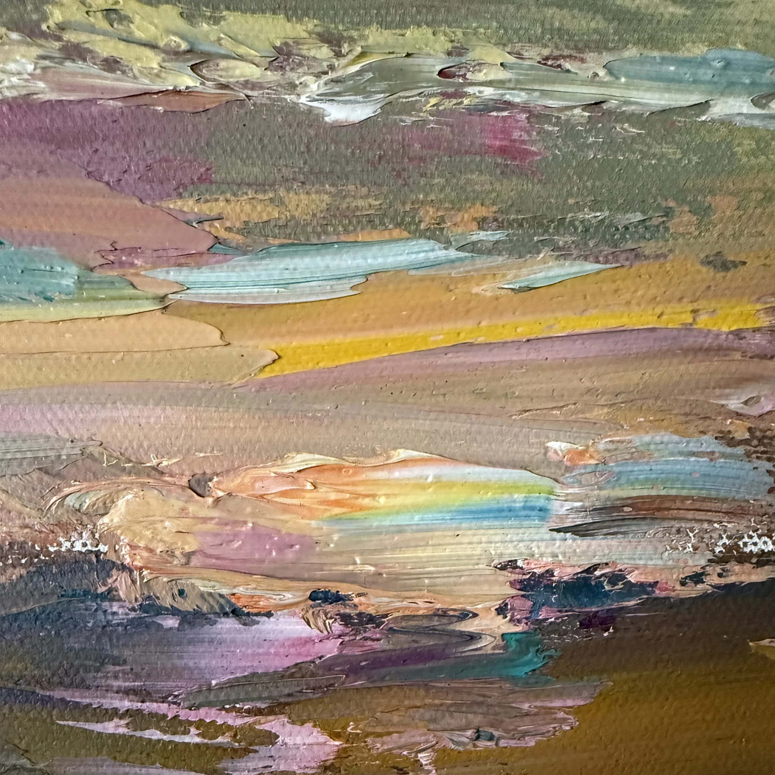 Close-up of multicolored paint strokes on canvas, including shades of yellow, pink, purple, green, and blue.
