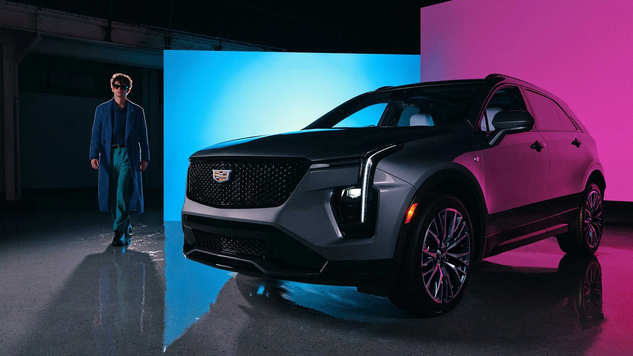 male model walks up to silver Cadillac suv