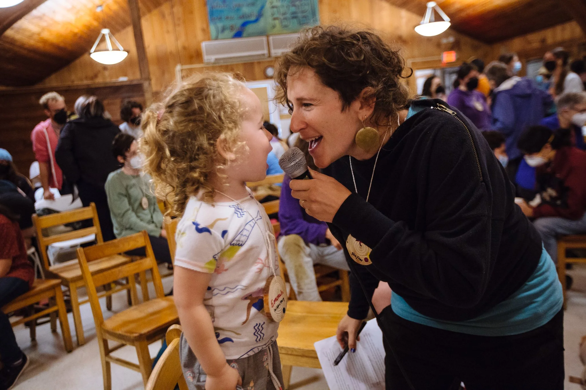 An adult and a child sing into the microphone together