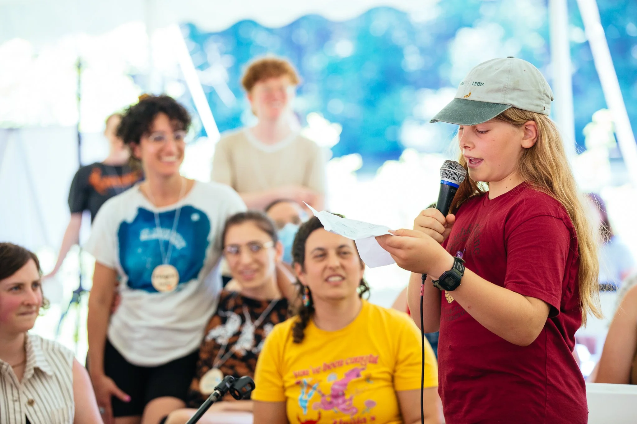 A young person teaches a song to the group that they wrote during the retreat