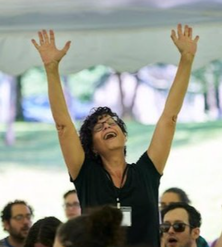 Photo of MJ singing with hands raised in the air
