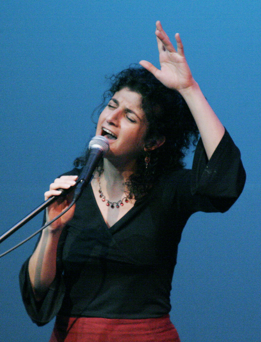 A photo of Galeet singing at a mic