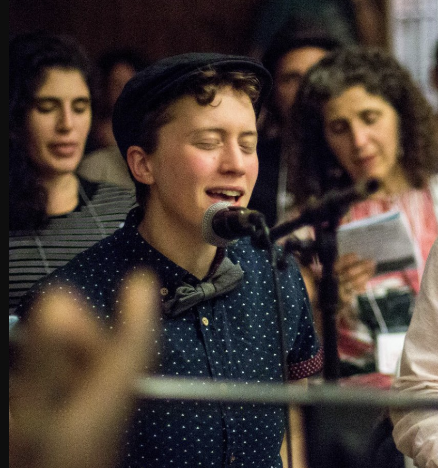 A photo of Rabbi Noam singing into a mic
