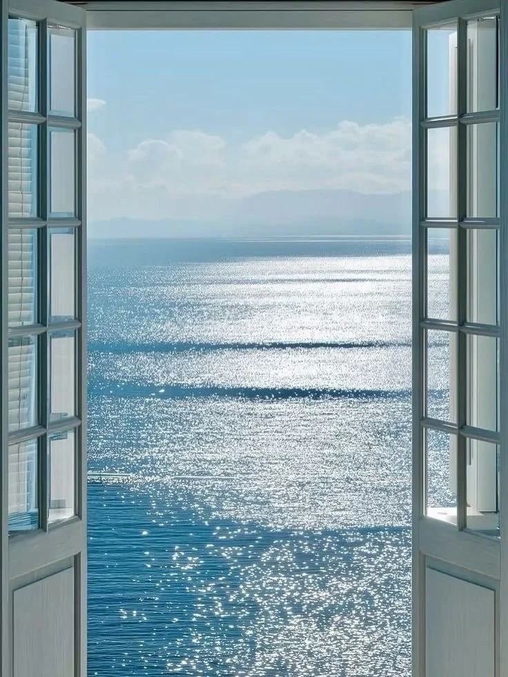 Open window showing a bright ocean view with shimmering water and a distant horizon.