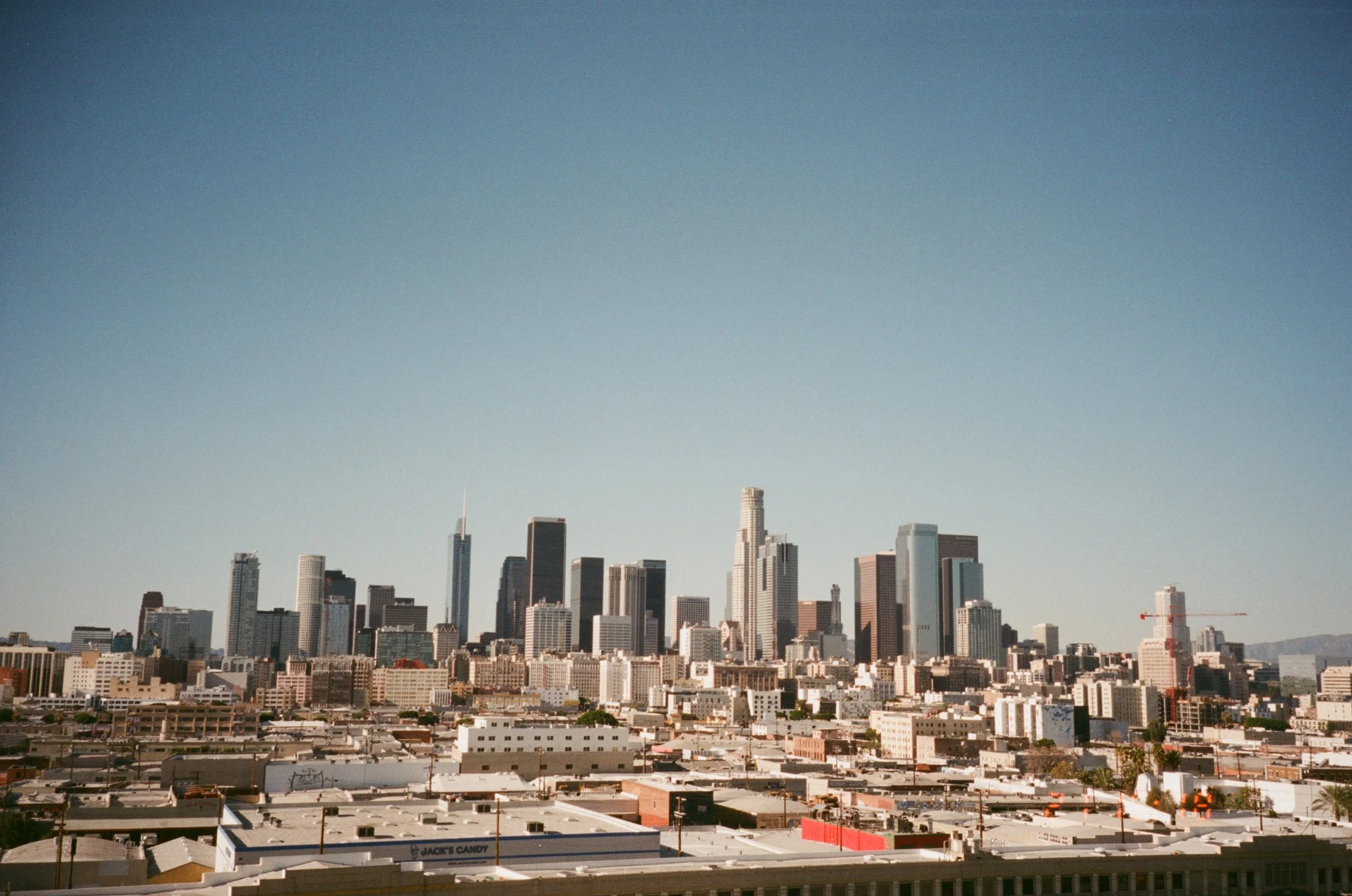 A city skyline featuring tall skyscrapers and buildings against a clear blue sky.