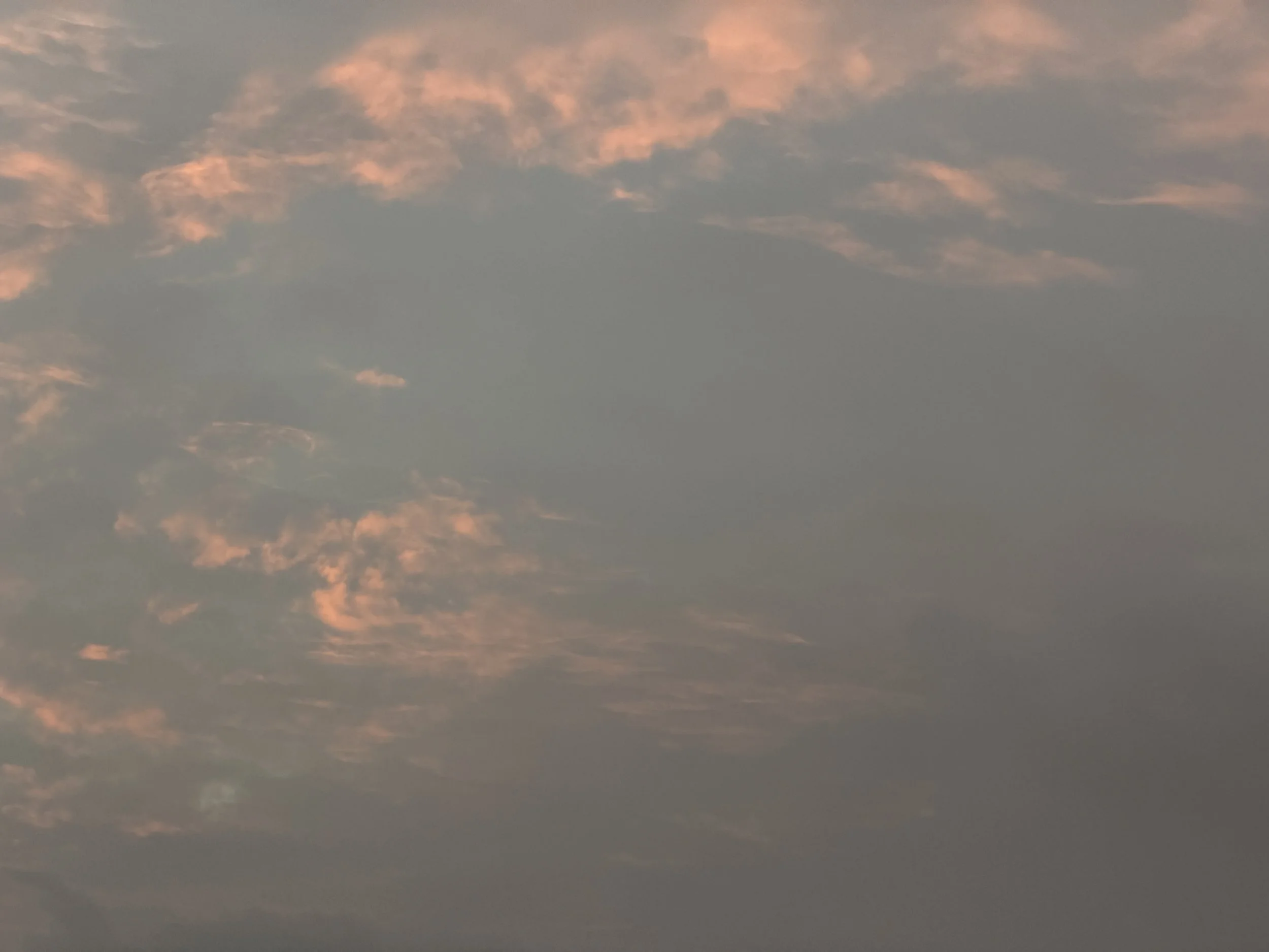 A sky with some pink and orange clouds during sunset or sunrise.