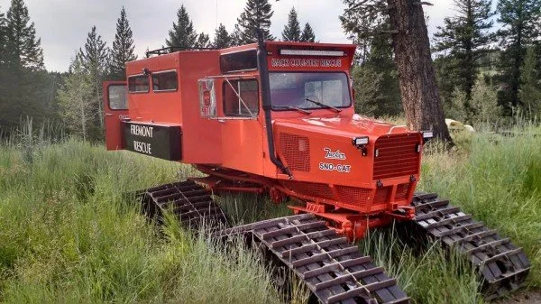 A red rescue vehicle with treads in a grassy field, with trees in the background, labeled "Fremont Rescue" and 