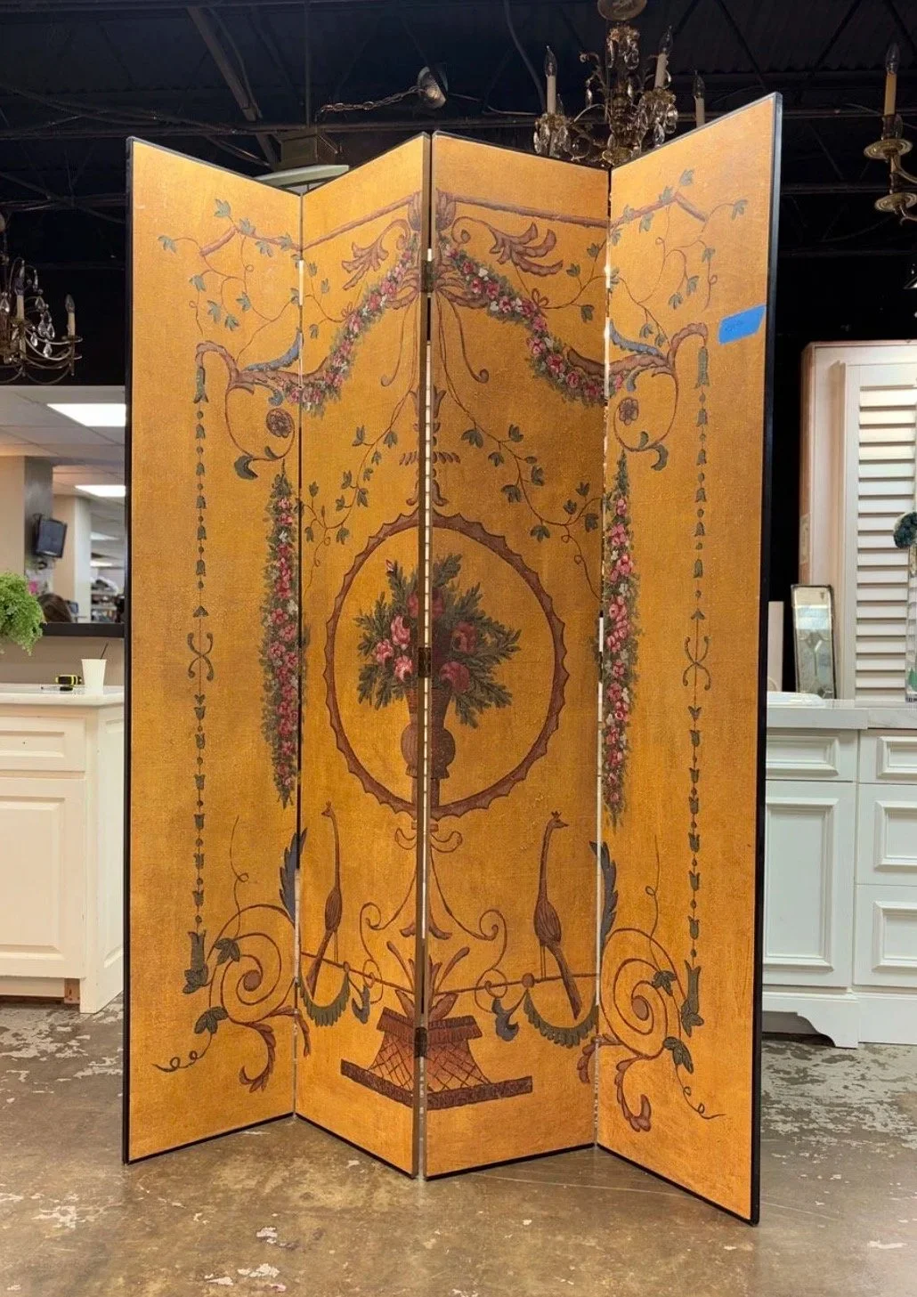 Decorative folding screen with a floral and urn design on a gold background.
