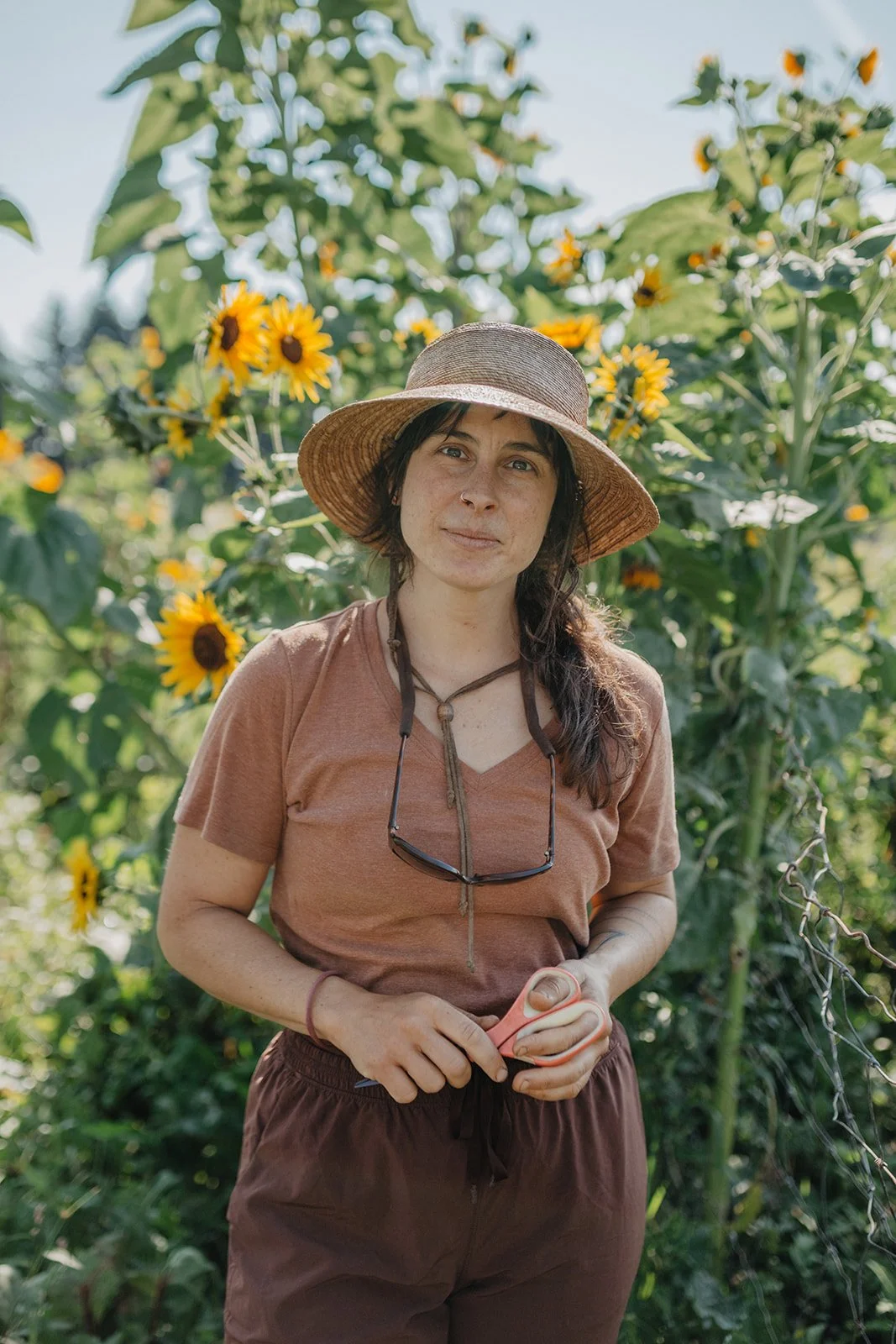 Ellie stands in front of a sunflower backdrop.