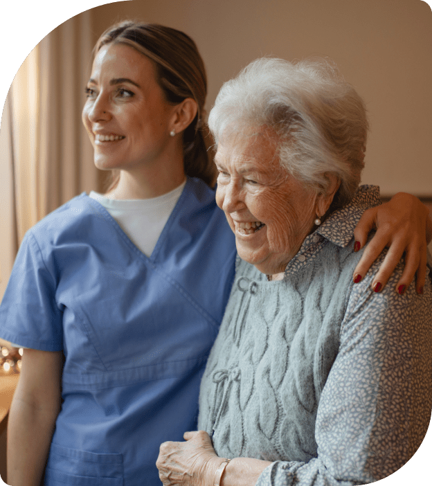 Rosebuds Home Care Logo ( Compassionate Care by local for locals) - "WHERE CARE BLOSSOMS AT HOME"A Rosebuds' caregiver hugging an elderly woman with gray hair, both smiling and looking happy.