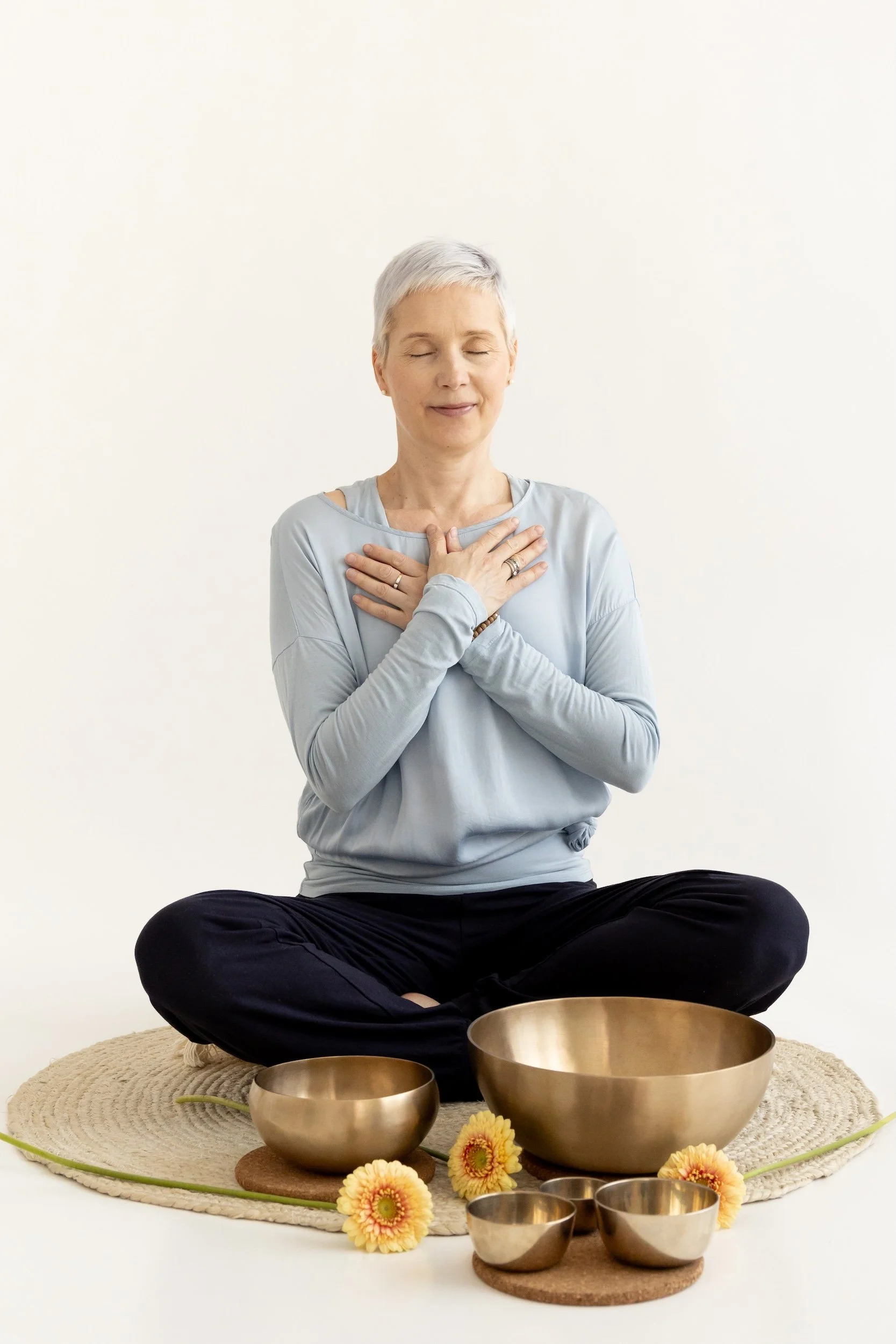 Sunni Perki istuu ristikkäin jaloin tyynyn päällä kääntyen hieman vasemmalle, kädet sydämen yläpuolella rintakehän päällä. Hänellä on lyhyet harmaat hiukset ja hän kokee rauhaa.