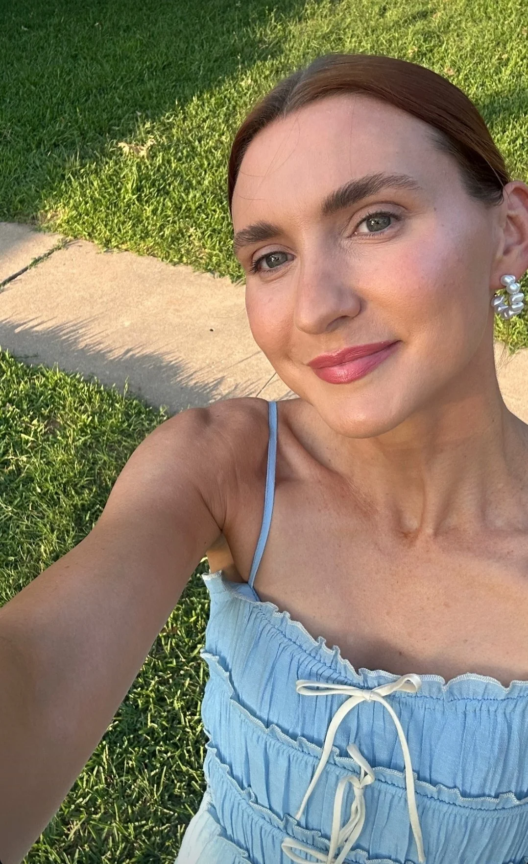 Client showing glowing caramel spray tan from Caramel Tan ATX.