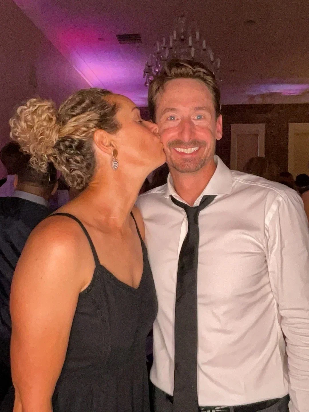 Caramel Tan spray tan for wedding guest in cocktail dress with radiant bronze skin.