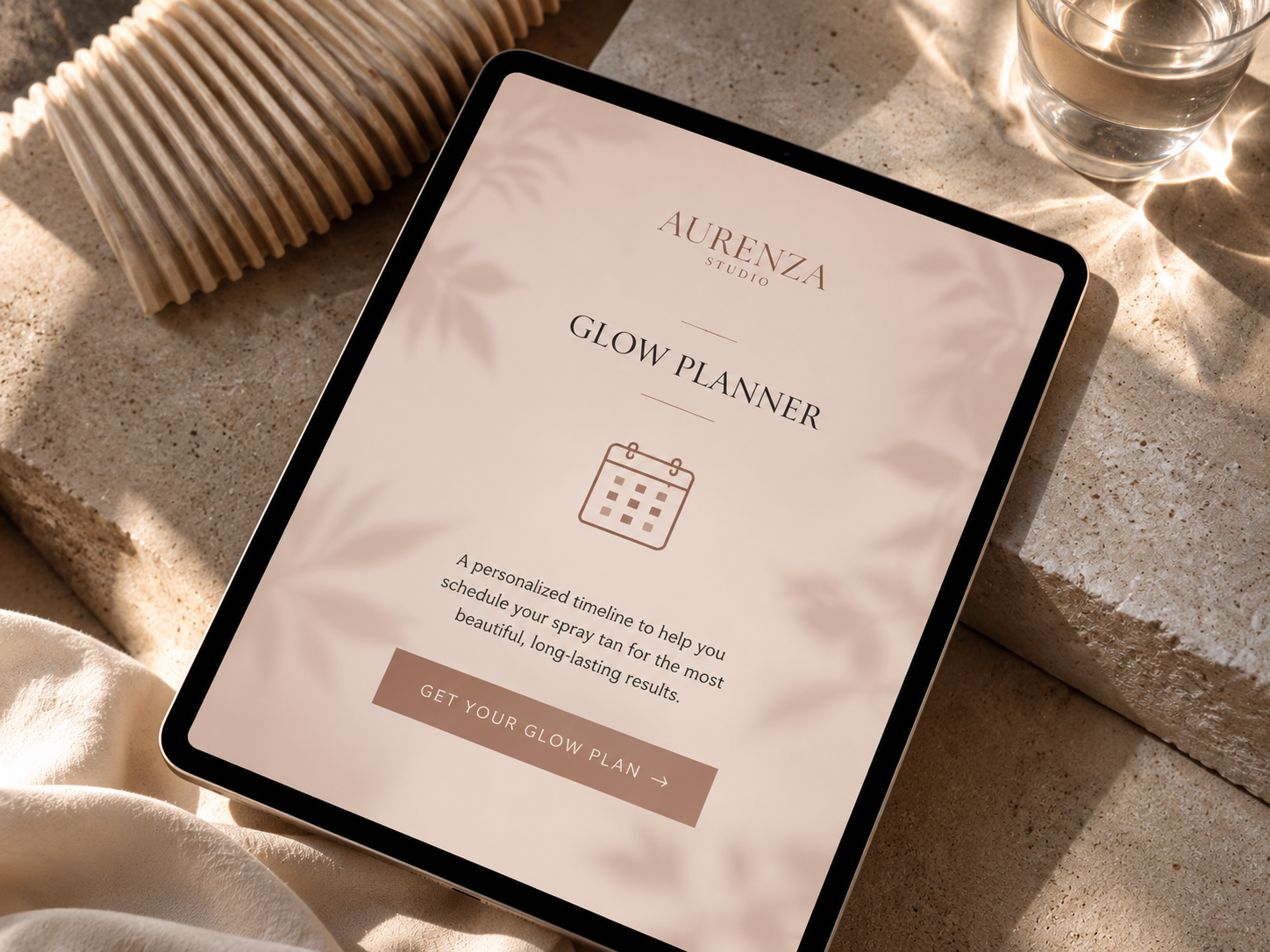 Aurenza Studio Glow Planner displayed on a tablet, helping clients schedule their spray tan before weddings and special events.