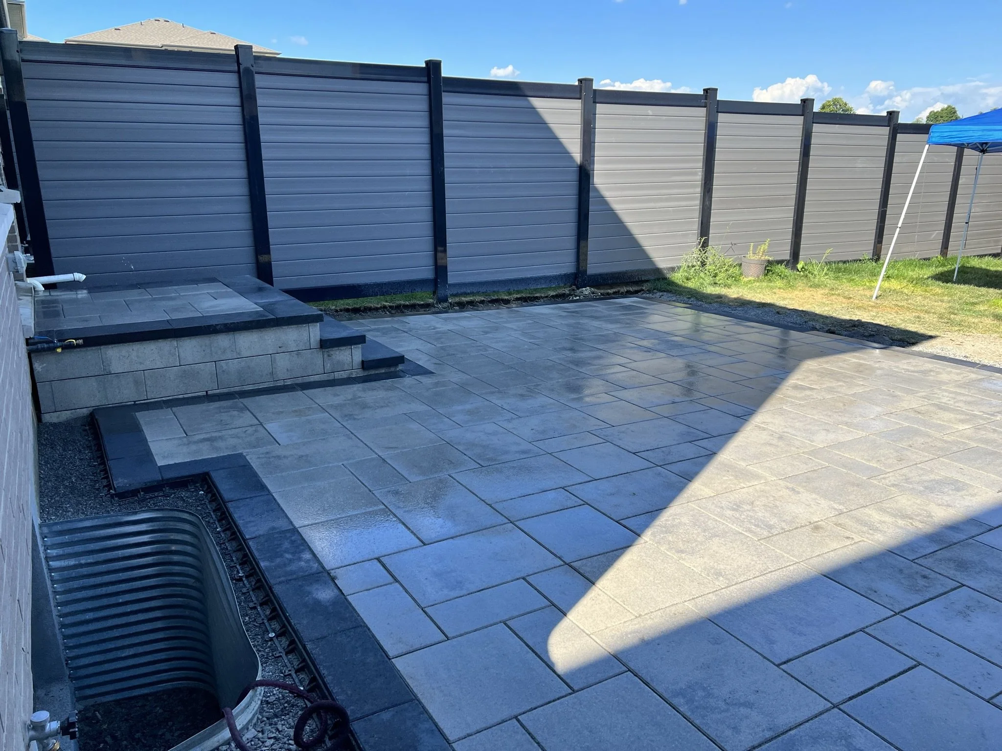 Finished interlock patio with large stone tiles in Ottawa backyard