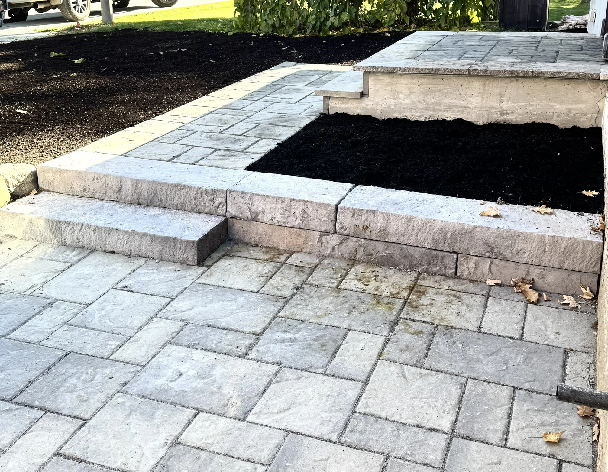 Interlock patio with steps and raised seating area construction in Ottawa