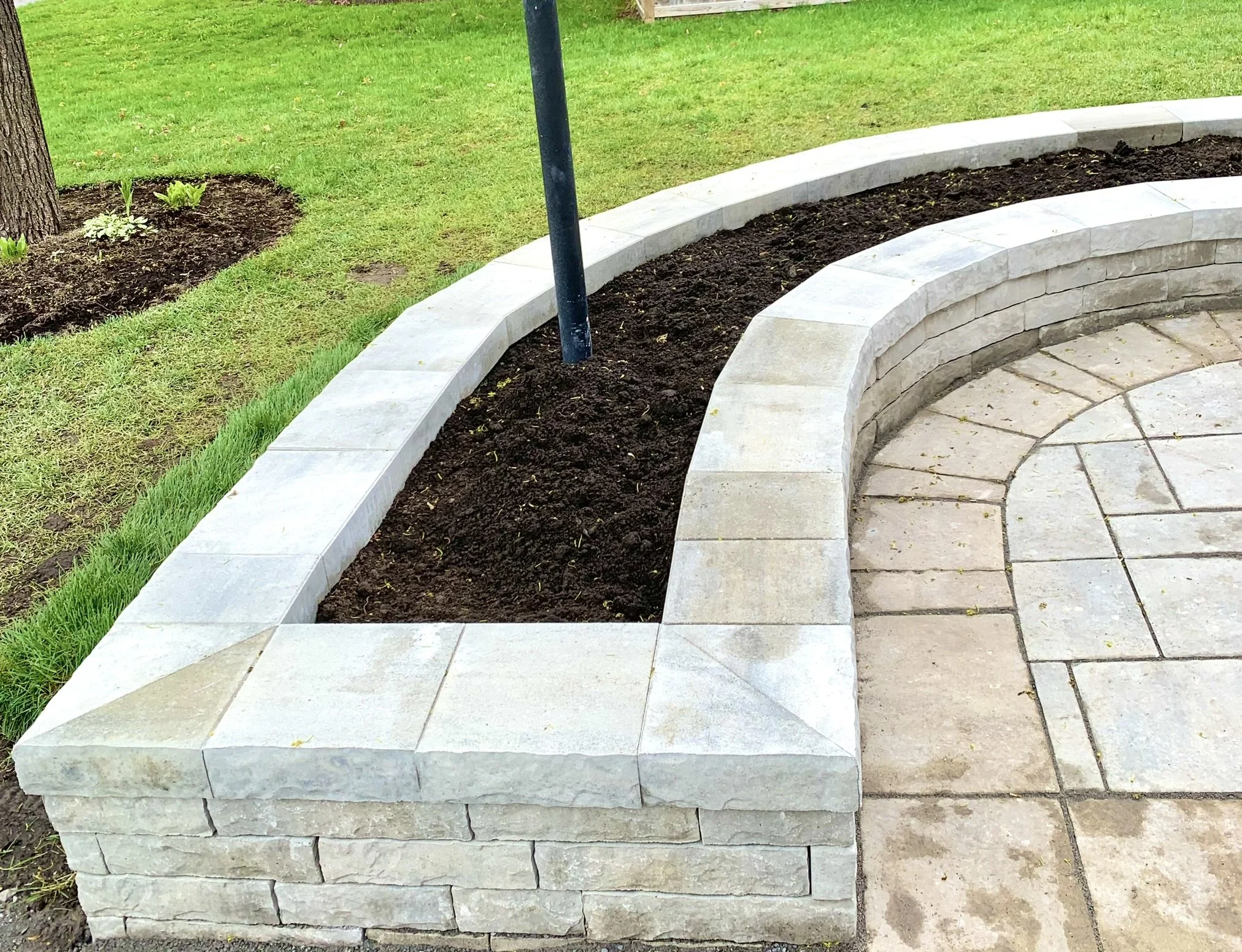 Curved stone planter and interlock walkway detail in Ottawa