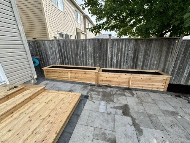 Backyard landscaping with wood deck and custom planter boxes in Ottawa