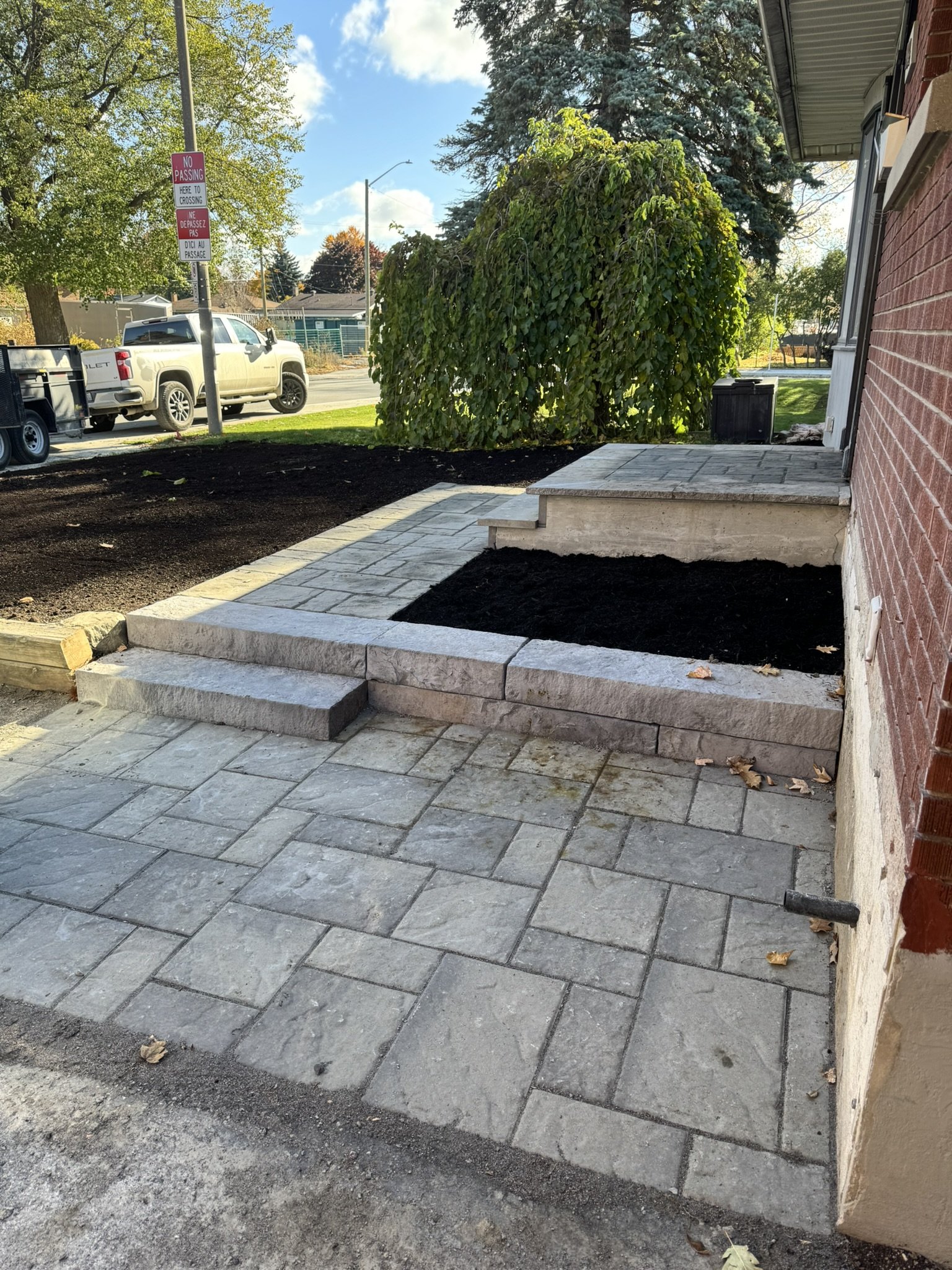 Interlock patio installation with step and project sign in Ottawa
