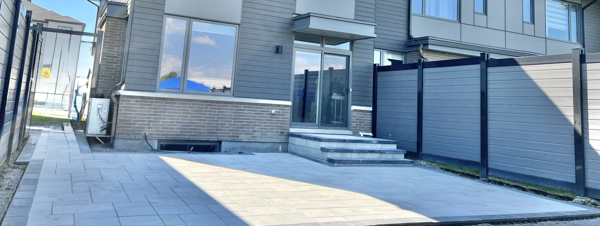 Modern backyard with interlock patio, steps, and clean hardscape design in Ottawa