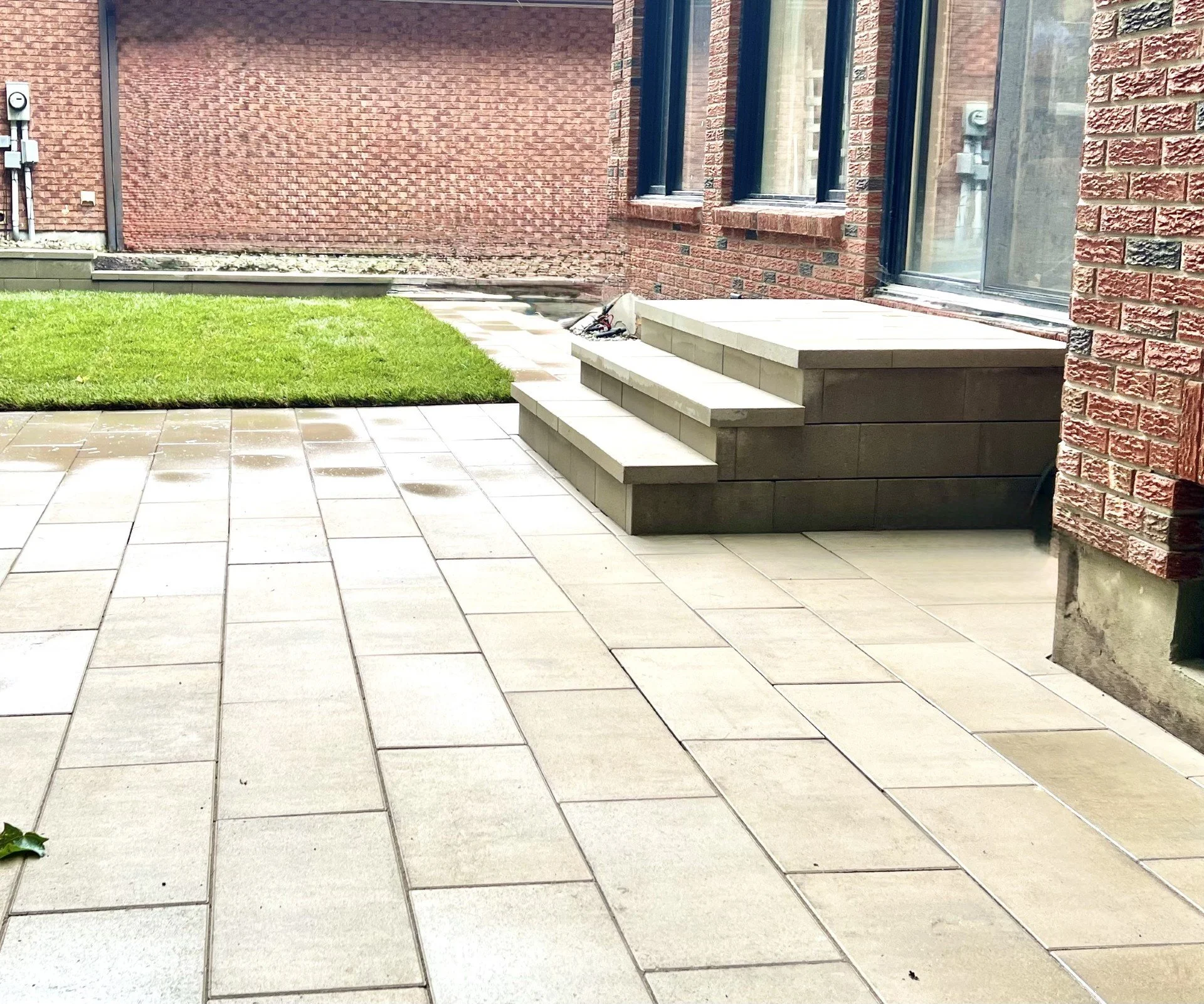 Backyard interlock patio with steps and grass area in Ottawa