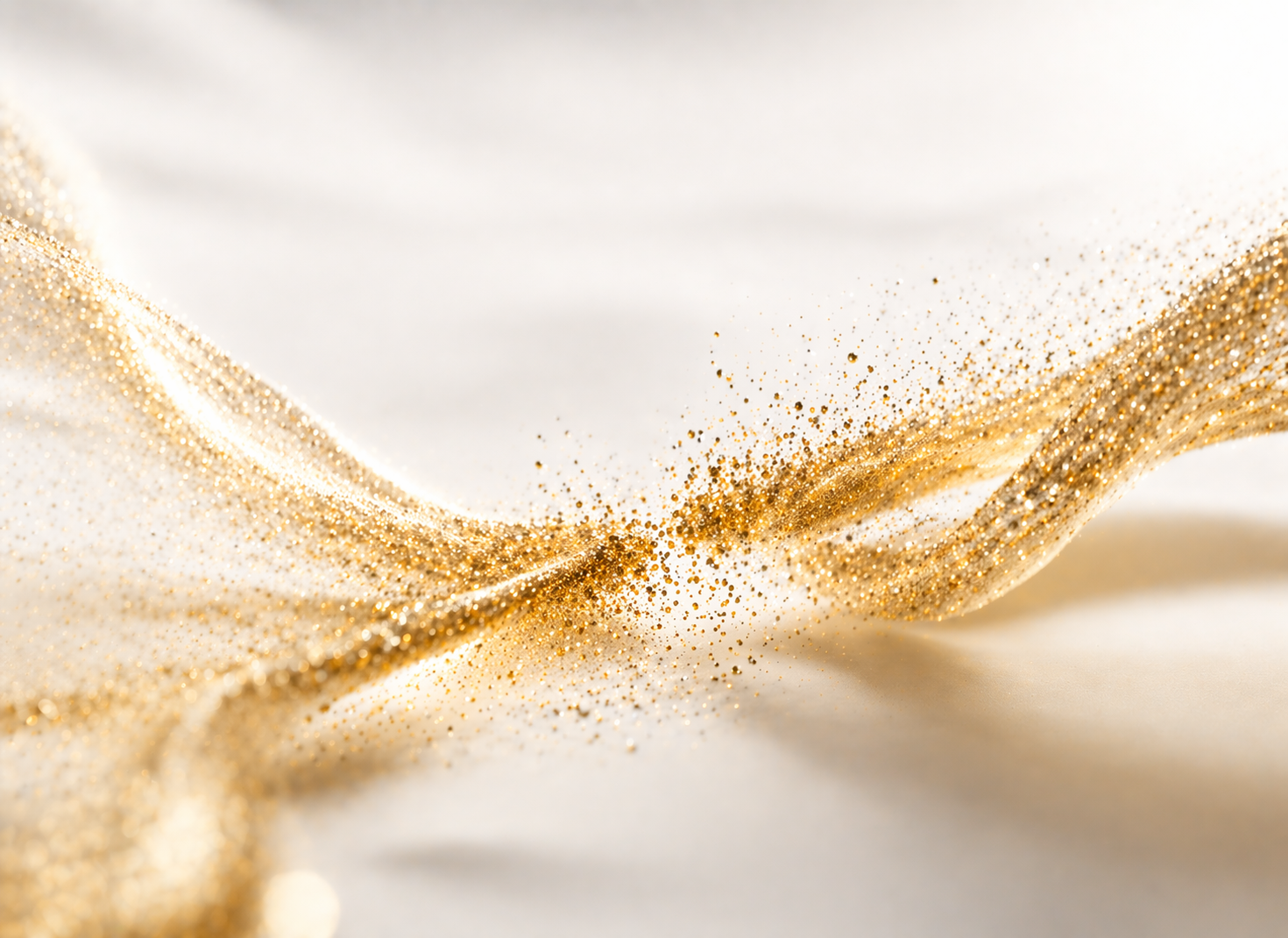 Close-up of golden glitter on white fabric with flowing curves.