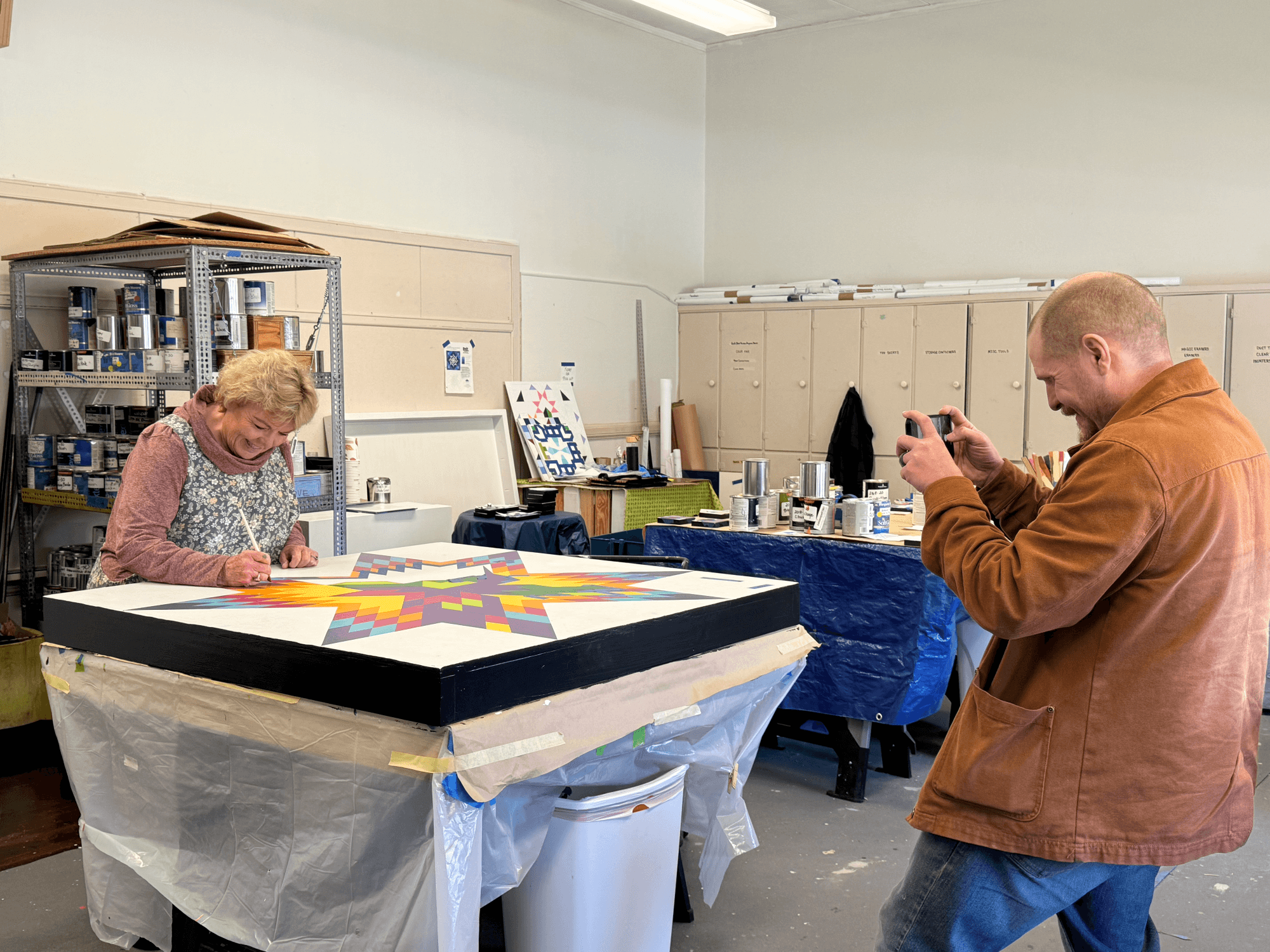 Danna painting a barn quilt block in the studio