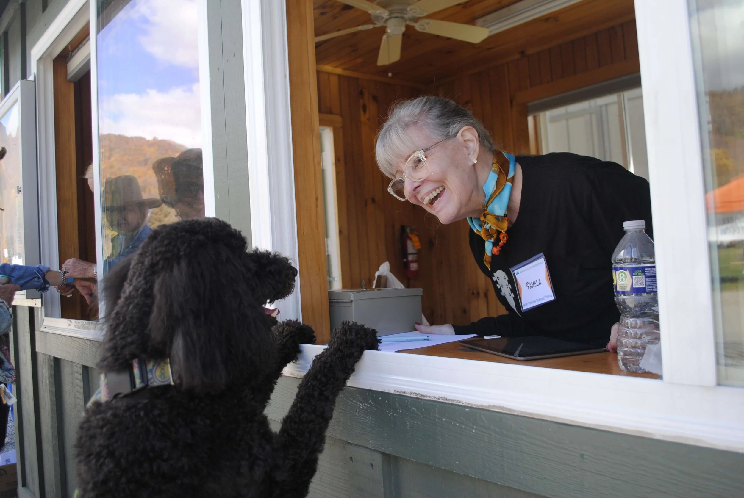 Volunteer Greets Dog at the Ticket Gate