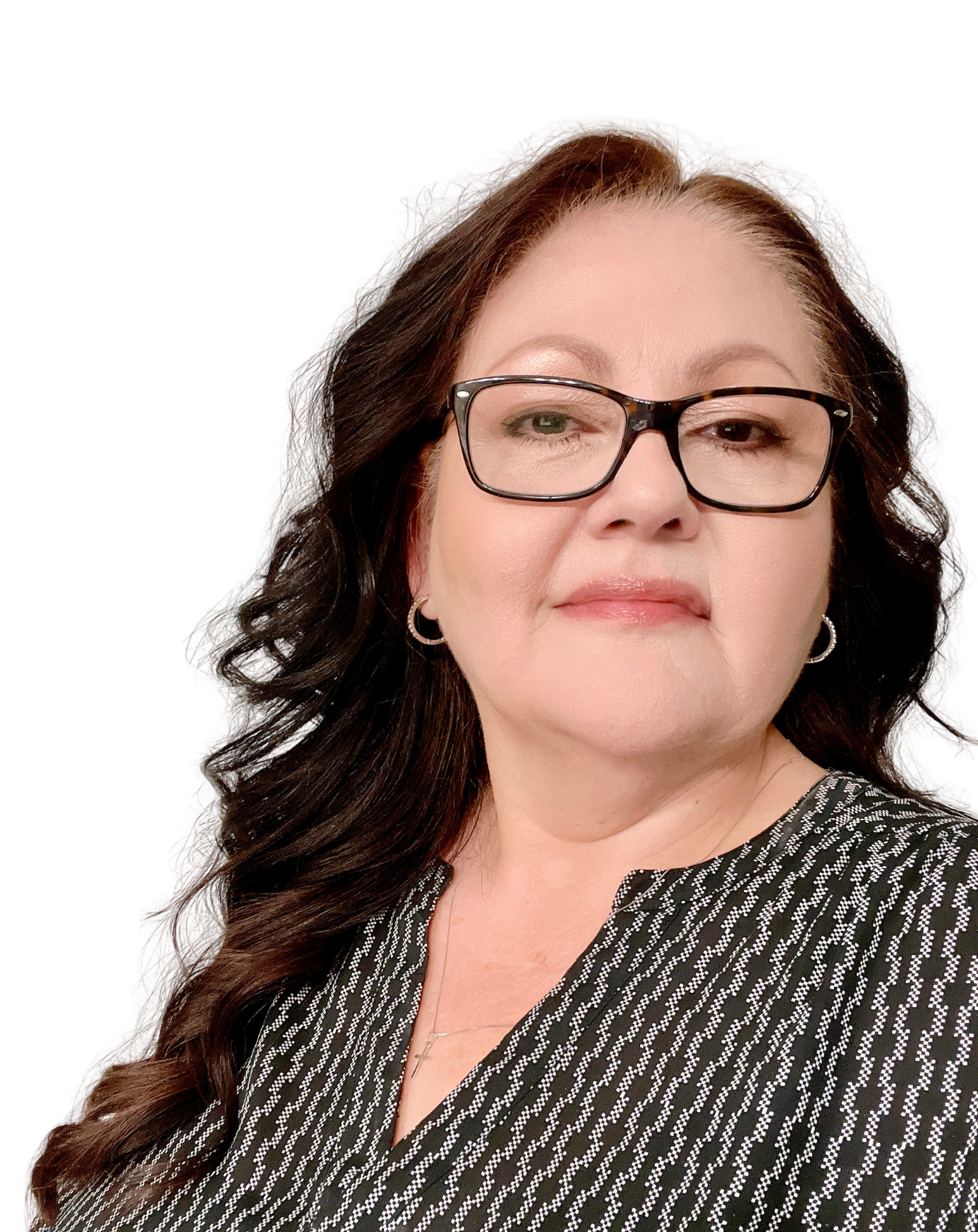A woman with long dark hair, glasses, and hoop earrings wearing a black and white patterned top against a plain white background.