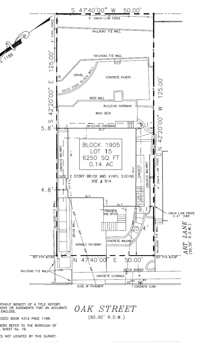 Detailed architectural site plan of a property, including dimensions, fencing, driveways, and building features such as concrete walkways and a wood deck.